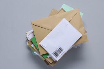 Stack of different paper envelopes on light grey background, top view. Post office