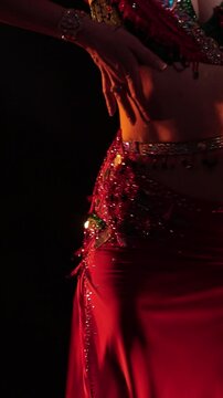 Dancer in black and gold oriental costumes, belly dance on the black background