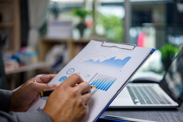 Business document reviewing charts and graphs for data analysis statistical reports at the office.