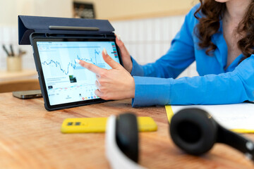 Businesswoman analyzing financial data on tablet for trading strategy