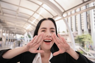 A cheerful woman smiling and shouting with joy, creating a vibrant and energetic atmosphere in an...