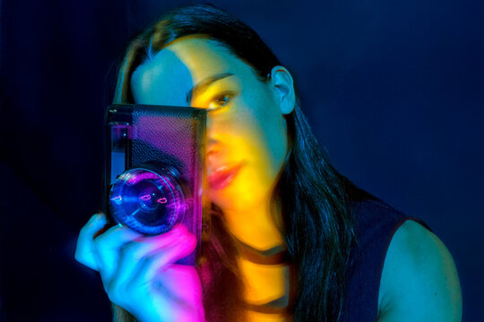 Blurred portrait of a woman with vintage camera and light