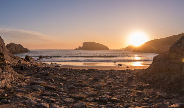 Golden Sunrise Lighting the Shoreline at Arnia Beach, Cantabria