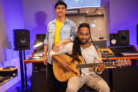 Musicians in modern recording studio creating music together - Powered by Adobe
