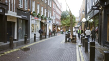 Blurred street scene in london with defocused pedestrians walking in seven dials amidst bokeh...