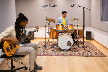 Musicians in a modern recording studio, drums and bass session