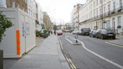 Blurred street view in london captures urban ambiance with cars, buildings, and a defocused perspective, accentuating winter tones in a quintessential uk setting.