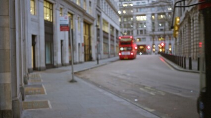 Blurred view of a quiet london street in winter with iconic red double-decker bus and historic buildings creating a classic united kingdom urban winter scene.