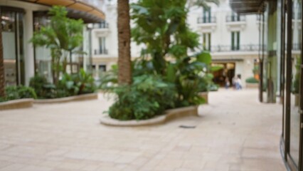 Fototapeta premium Blurred outdoor scene in luxury monaco street, with bokeh effect and lush greenery, offering a defocused urban background under bright skies, showcasing an elegant atmosphere.