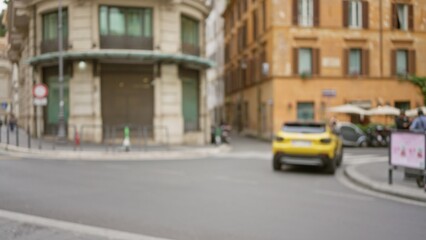 Street scene in rome featuring blurred buildings and a defocused yellow car passing by on an old town road with a warm european city atmosphere.