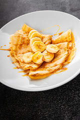 Crepes sweet banana syrup pancakes breakfast dish dessert organic product fresh tasty gourmet food background on the table rustic food top view copy space