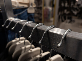 A row of clothes hanging on a rack in a clothing store