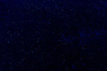 Dark blue textured surface with scattered light specks
