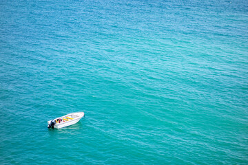 Empty motor boat anchored / adrift in vast beautiful turquoise ocean water