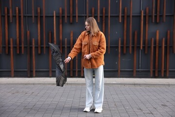 Teenage girl with black broken umbrella outdoors © New Africa
