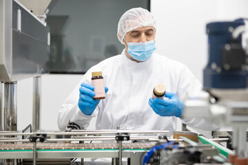 Naklejka premium A focused health professional inspecting product labels in a lab, ensuring standards and quality in the cosmetic industry.