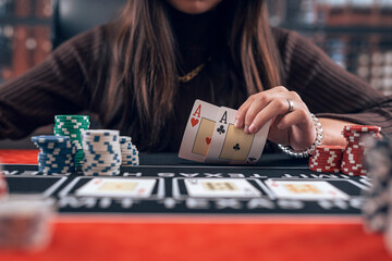  female player holding ace playing cards as win combination in poker game