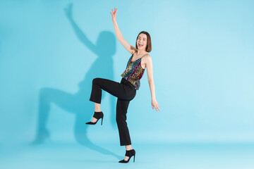 Obraz premium Happy woman dancing on light blue background