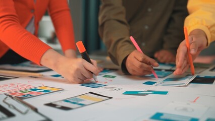 A dynamic teamwork scene captures individuals engaged in a creative design process, sketching user interface ideas with vibrant markers on paper in a collaborative workspace. SACTR