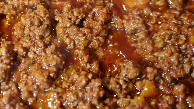 
Cooking and stirring meat bolognese sauce. Italian ragu for pasta includes sauteed minced vegetables with ground beef, pork and tomato. Close up footage, food background.
