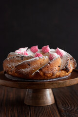 Traditional Easter cakes with icing decorated candies on dark wooden table