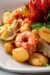 Gnocchi di patate con gamberi e carciofi, pasta italiana 