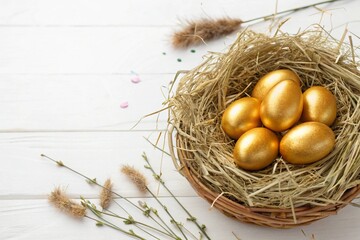 Fototapeta premium Happy easter postcard banner. Golden Easter eggs in straw nest on white background.