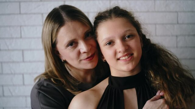 Mother and Daughter Posing Against White Brick Wal;