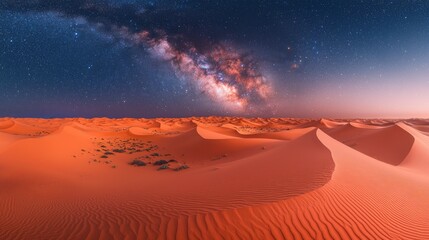 Vast, orange desert dunes under a vibrant night sky