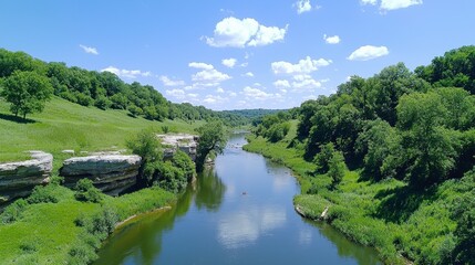 Obraz premium Serene River Surrounded by Lush Greenery Under Blue Sky