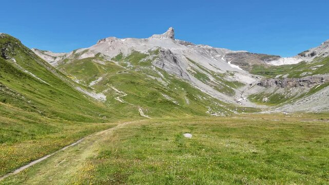 Flight over male hiker (man) with trekking backpack towards mountain panorama with summit Tita Seri in Swiss Alps, Switzerland