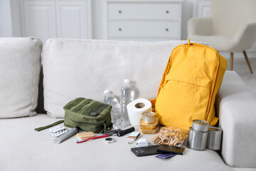 Survival kit. Different emergency supplies on sofa indoors
