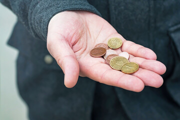 A few coins in men's hand, selective focus.	