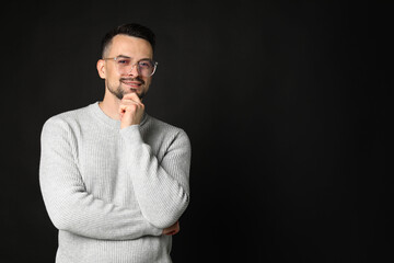 Fototapeta premium Portrait of handsome middle aged man on black background, space for text