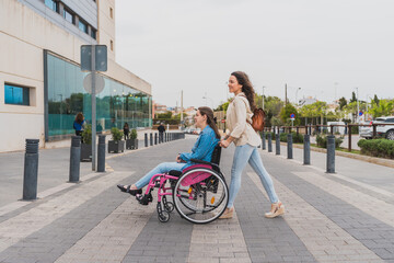 Young woman with cerebral palsy pushed by assistant near medical center - They move confidently...