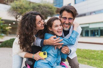 Young woman with cerebral palsy embraces doctor and caregiver - Smiling patient hugs healthcare worker and assistant during joyful moment. Concept of cerebral palsy.