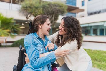 Young woman with cerebral palsy shares laugh with caregiver - Patient in wheelchair smiles joyfully...