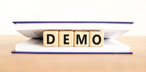 Demo symbol. Concept word Demo on beautiful wooden blocks in book. Beautiful wooden table white...