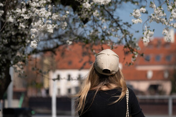 Blonde Woman Watching Blossoms in City