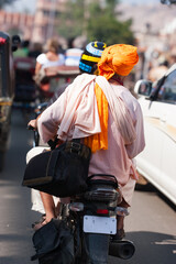 Two Indian men ride on a motorcycle through the congested streets of Jaipur