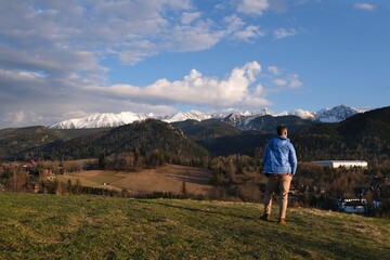 Naklejka premium Silhouette of standing man in blue jacket on beautiful viewpoint with Tatras mountains on Antalowka, Zakopane, Poland
