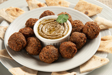 Arabic food dish with falafel, babaganuche and pita bread.
