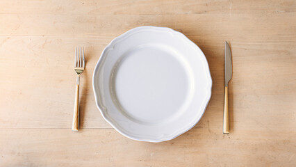 Empty plate, fork and knife on table