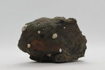 Calcite boules in a rock isolated on a white background 