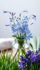 Delicate blue campanula blossoms in a glass vase, alongside vibrant green cut grass, floral, bloom, macro
