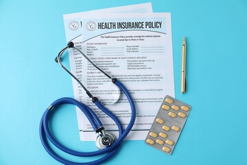 Health insurance policy forms, stethoscope, pills and pen on light blue background, flat lay