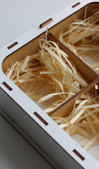 Wood shavings inside the compartments of a plywood box for transporting fragile items. Parcel box...