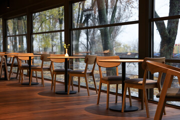 Stylish cafe with large windows and comfortable furniture. Interior design