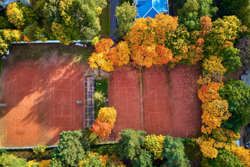 Aerial view of a tennis court surrounded by beautiful trees