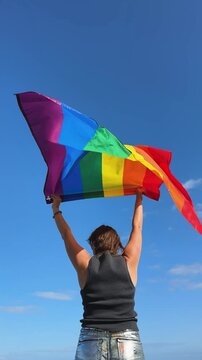 Gay pride parade, woman woman holding flag with rainbow lgbt flags